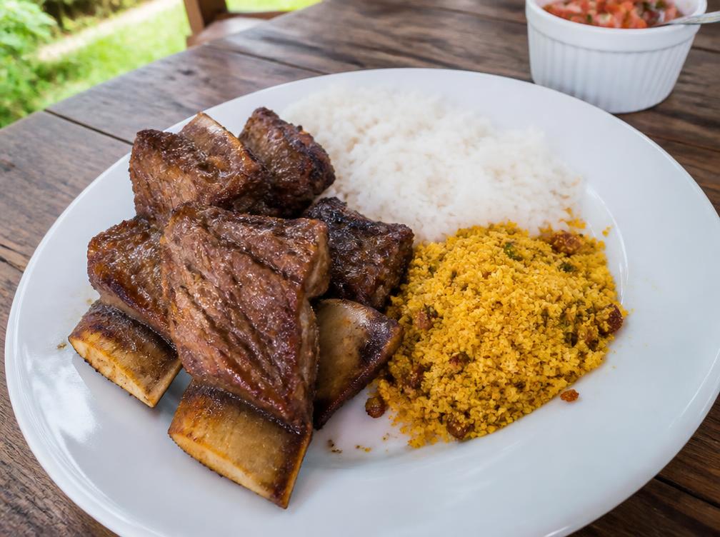 Prato montado com fatias de costela, arroz e farofa